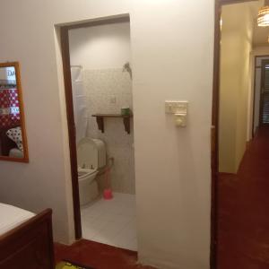 a bathroom with a toilet and a mirror at Casa Carlotta & Villa in Nungwi