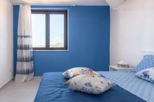 a blue bedroom with two pillows on a bed at Appartamento Le Primule in Agrigento
