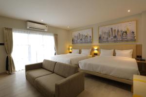 a hotel room with two beds and a couch at Hotel City Express Udaipur - My Downtown Hotels in Udaipur