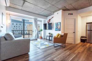 a living room with a couch and a window at Le coeur du Festival d'été de Québec in Quebec City