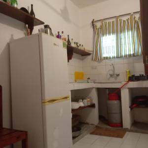a kitchen with a white refrigerator and a sink at Casa Carlotta & Villa in Nungwi