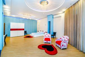 sala de estar con 2 sillas y lámpara de araña en NIzami Street 4 Room DeLuxe en Baku