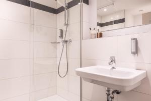 a bathroom with a sink, shower, and toilet at Select Hotel Mainz in Mainz