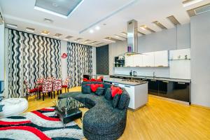 NIzami Street 4 Room DeLuxe في باكو: غرفة معيشة مع أريكة ومطبخ