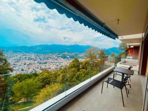 a balcony with a table and a view of a city at Appartamenti da sogno in Lugano