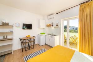 a room with a bed and a table and a kitchen at Apartments by the sea Podaca, Makarska - 9712 in Podaca