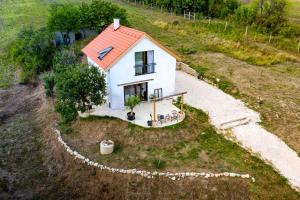 a small white house with a red roof on a hill at KalácsHáz Dörgicse in Dörgicse