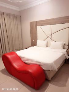 1 dormitorio con 1 cama con silla roja en جولدن أبها المضياف en Abha
