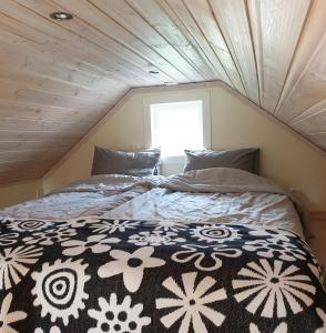 Bett in einem kleinen Zimmer mit Fenster in der Unterkunft Cabin near lake and beautiful nature reserve. in Bodafors