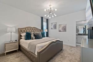 a bedroom with a large bed and a chandelier at Beautiful Family Villa - Pool and Hot Tub - Near Disney World in Kissimmee