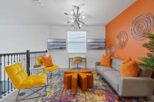 a living room with orange walls and yellow chairs at Beautiful Family Villa - Pool and Hot Tub - Near Disney World in Kissimmee