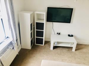 a living room with a tv and a white table at Charming Town centre 3 double beds home free parking in Tonbridge