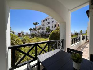 einen Balkon mit einem Tisch und Blick auf ein Gebäude in der Unterkunft Lilac's GARDEN in Cabo Negro