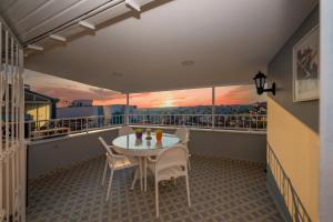 balcón con mesa, sillas y puesta de sol en Taxim Trend Suites, en Estambul