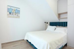 a bedroom with a white bed and a painting on the wall at Apartments by the sea Podstrana, Split - 9714 in Podstrana
