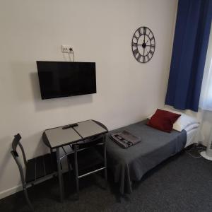 um quarto com uma cama e uma mesa e um relógio na parede em Rybaki 6A em Poznań