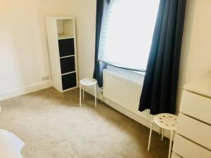 a bedroom with two chairs and a window at Charming Town centre 3 double beds home free parking in Tonbridge