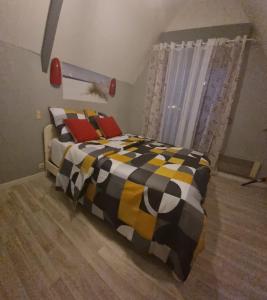 1 dormitorio con 1 cama con manta negra y amarilla en Belle chambre avec balcon, en Arques