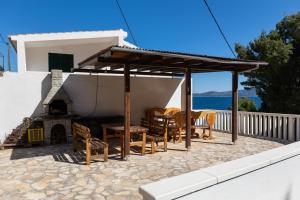 un patio con mesa, sillas y chimenea en Apartments by the sea Mimice, Omis - 2736 en Mimice