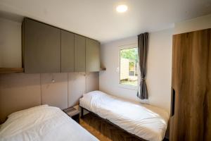 two beds in a small room with a window at Urban Gardens Gent in Ghent
