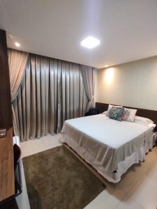 a bedroom with a large bed in a room with curtains at Hotel Universal in Santarém