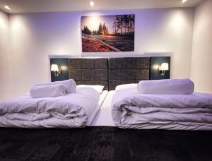 a bedroom with two beds and a painting on the wall at NRing Villa am Nürburgring in Adenau