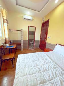 een slaapkamer met een groot wit bed en een bureau bij Hà Anh Hotel in Pleiku