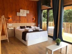 um quarto com uma cama num quarto com paredes de madeira em Cabañas Compostela - Cabaña Pedroso con bañera de hidromasaje em Santiago de Compostela