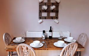 uma mesa de madeira com cadeiras e uma garrafa de vinho em Lovely 2 Bedroom with Riverside Views Pet Friendly em Gourock