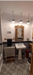a bathroom with a sink and a mirror and a radiator at Lovely 2 Bedroom with Riverside Views Pet Friendly in Gourock