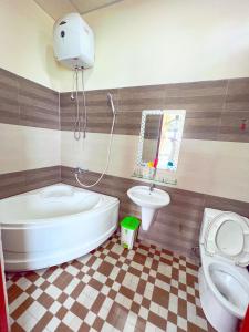 een badkamer met een bad, een toilet en een wastafel bij Hà Anh Hotel in Pleiku