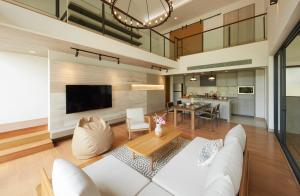 Ban Sathani Bandai MaMarasca Khao Yai - Eco-friendly Glamping Escape Near National Park的客厅里有一张白色的沙发和一张桌子