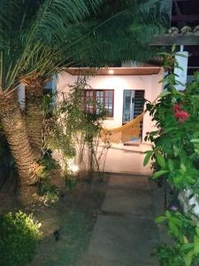 une maison avec un palmier en face dans l'établissement Casa em Village com piscina e perto da praia, à Salvador