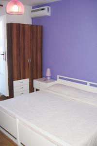 a bedroom with a white bed and a blue wall at Apartments and rooms with parking space Bol, Brac - 2878 in Bol