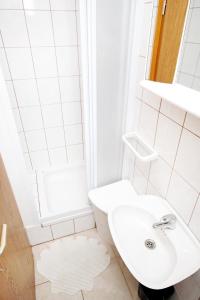 a white bathroom with a sink and a shower at Apartments and rooms with parking space Bol, Brac - 2878 in Bol