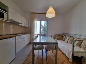a kitchen and living room with a table and a couch at Apartment Duce 2821c in Duće