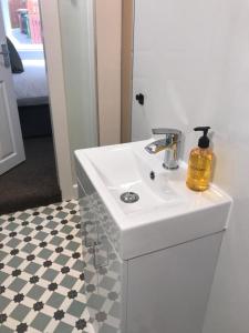 een badkamer met een witte wastafel en een spiegel bij 1Bed Golfhill Cottage in Dunblane