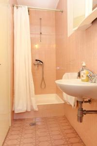 a bathroom with a sink and a tub and a shower at Apartments by the sea Duce, Omis - 2829 in Duće