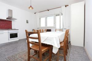 a kitchen and dining room with a table and chairs at Apartments by the sea Duce, Omis - 2829 in Duće