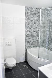 a bathroom with a tub and a toilet and a shower at Apartments by the sea Omis - 2822 in Omiš