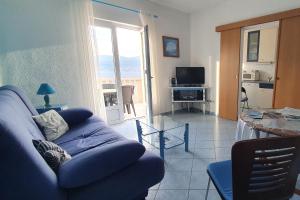 a living room with a blue couch and a glass table at Apartments with a parking space Postira, Brac - 2911 in Postira