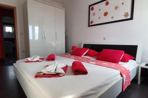 a white bed with red pillows and towels on it at Apartments with a parking space Postira, Brac - 2911 in Postira