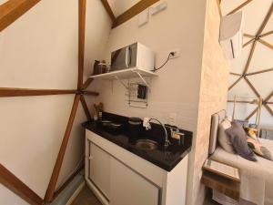 a kitchen with a sink and a microwave at Domo da Cuesta - Glamping com vista para a montanha in Bofete