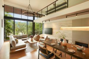 a living room with a dining table and a couch at Marasca Khao Yai in Ban Sathani Bandai Ma