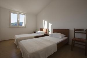 a bedroom with two beds and a chair and a window at Apartments by the sea Razanj, Rogoznica - 2970 in Rogoznica