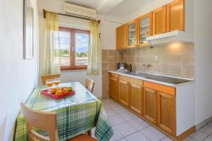a kitchen with a table with a bowl of fruit on it at Apartments by the sea Sumartin, Brac - 2952 in Sumartin
