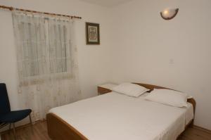 a bedroom with a white bed and a window at Apartments with a parking space Postira, Brac - 2948 in Postira