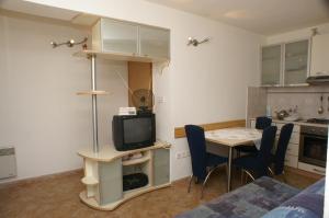 ein Wohnzimmer mit einer Küche und einem Tisch mit einem TV in der Unterkunft Apartments with a parking space Postira, Brac - 2948 in Postira