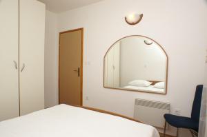 a bedroom with a mirror and a bed at Apartment Postira 2948b in Postira