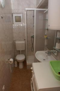 La salle de bains est pourvue de toilettes, d'une douche et d'un lavabo. dans l'établissement Apartment Postira 2948b, à Postira